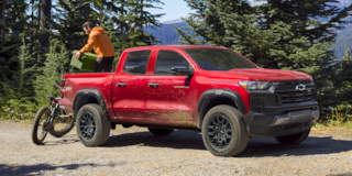 A Man Unloads His Bike from the Cargo Bed of His Colorado Trail Boss