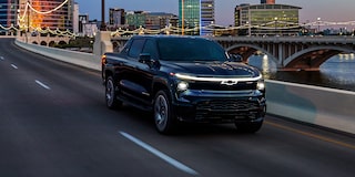 Three quarter view of a black 2025 Silverado EV a road in the evening