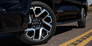 Low angle view of the tires of a black 2025 Chevy Silverado EV on a road