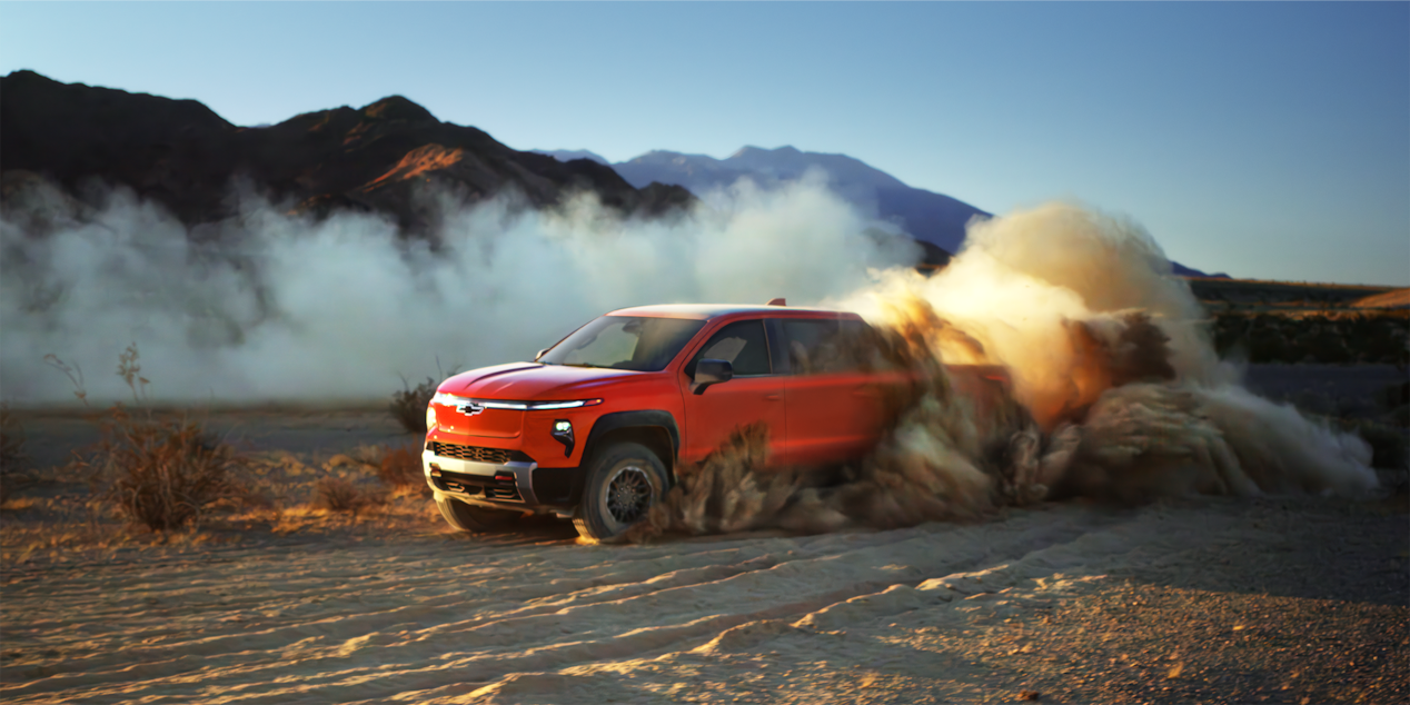 A 2025 Chevrolet Silverado EV Trail Boss Burn Outs Causing a Gust of Dirt in the Desert Near the Mountains