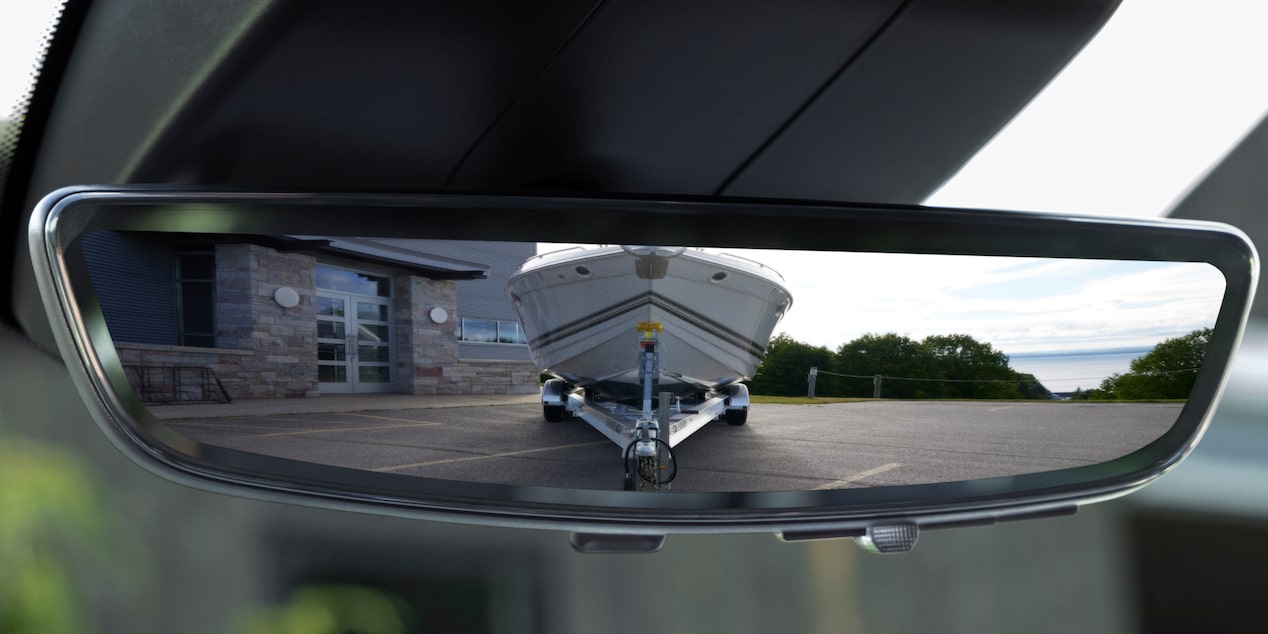 Close-up of a Rear View Mirror Reflecting a Boat Behind