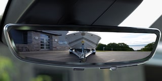 Close-up of a Rear View Mirror Reflecting a Boat Behind
