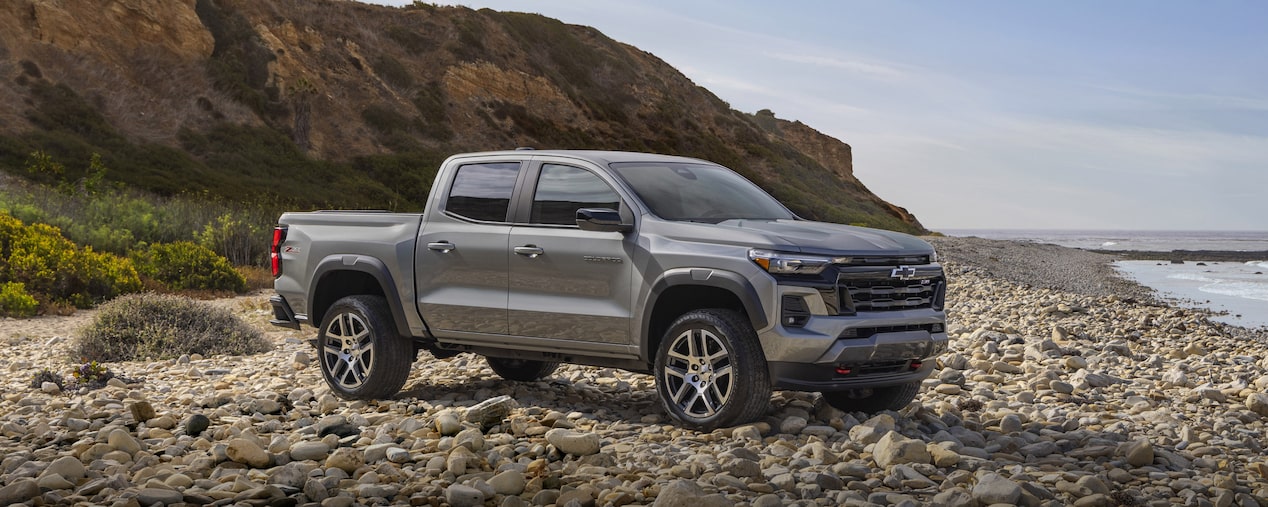  Three Quarters View of a Grey Chevy Colorado on a Rocky Plane Next to a Hill