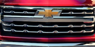 A Black 2025 Chevy Silverado Pickup Truck Pulling a Trailer with Sunlight from the Back