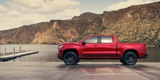 Three Quarters View of a Cypress Gray Chevy Silverado Pickup Truck kicking up mud
