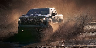 Three Quarters View of a Cypress Gray Chevy Silverado Pickup Truck kicking up mud