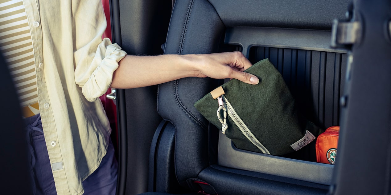 A Woman Pulling an Item Out of the Extra Storage Compartments in the 2025 Chevy Silverado