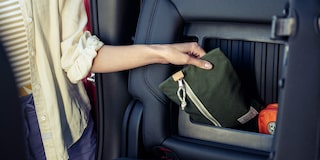 A Woman Pulling an Item Out of the Extra Storage Compartments in the 2025 Chevy Silverado