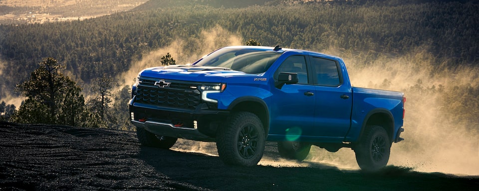 Side view of a 2025 Chevrolet Silverado LD ZR2 in Riptide Blue up a mountain