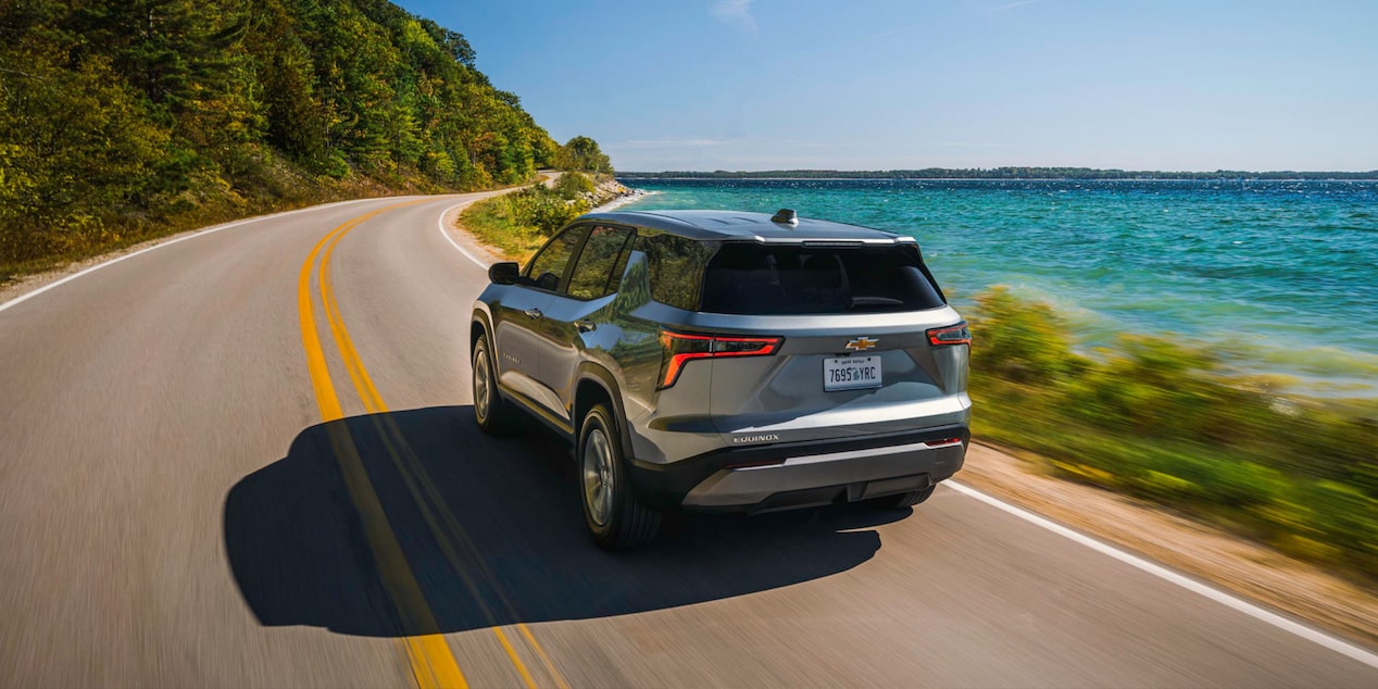 Rear End View of the 2026 Chevy Equinox Driving Along a Lake
