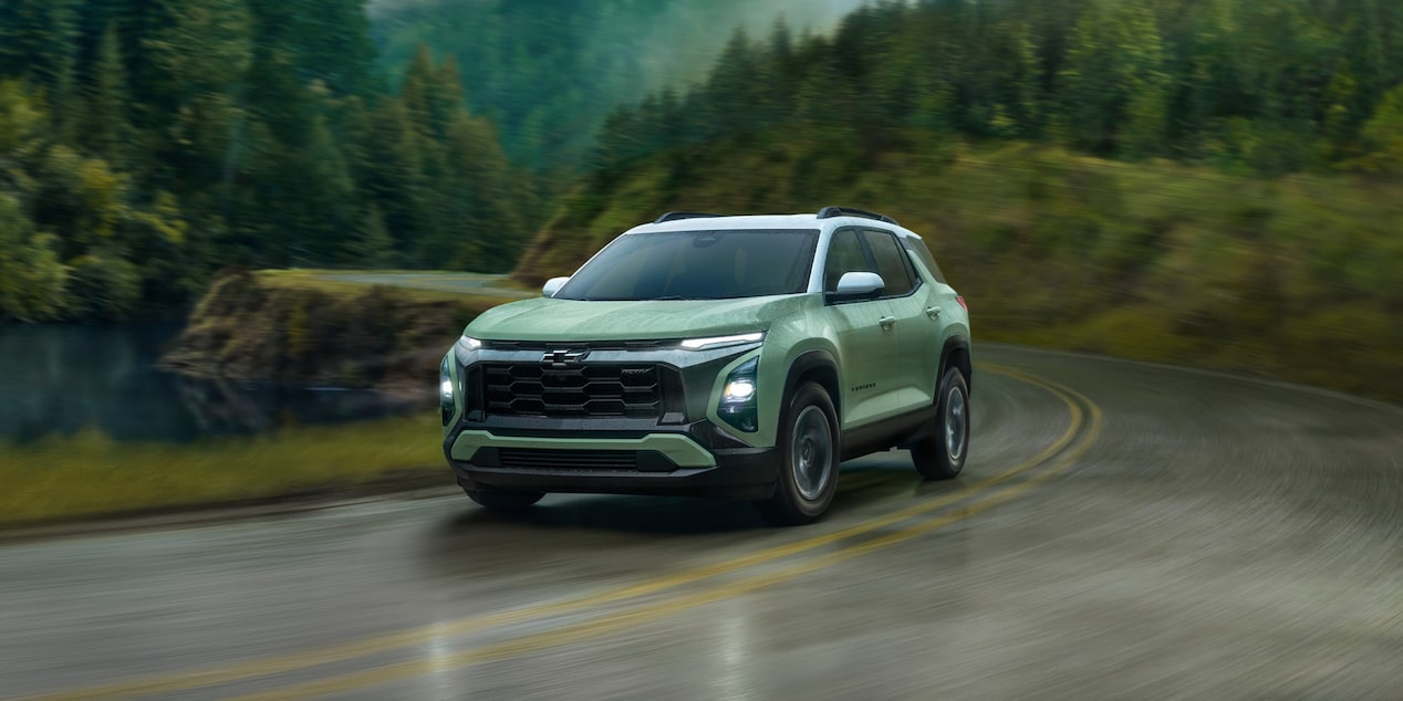2026 Chevy Equinox Driving Around a Bend in a Road Through the Forest