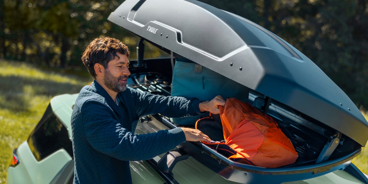A Man Storing Camping Gear in the Roof Rack Storage on His 2026 Chevy Equinox