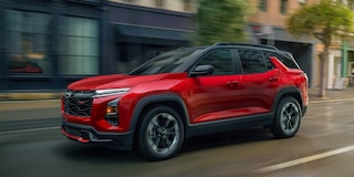 2026 Chevy Equinox Side Exterior View Driving Through a Downtown