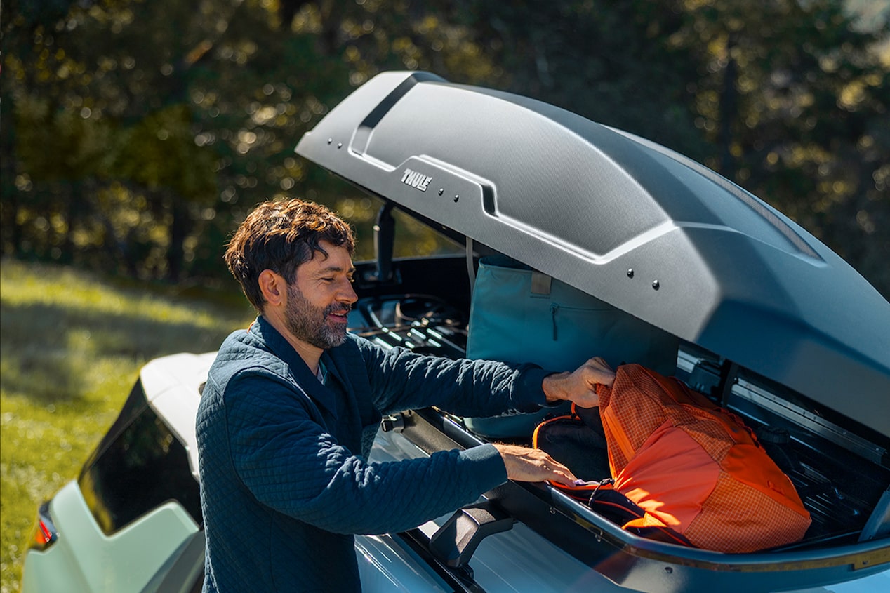 A Man Storing Camping Gear in the Roof Rack Storage on His 2026 Chevy Equinox