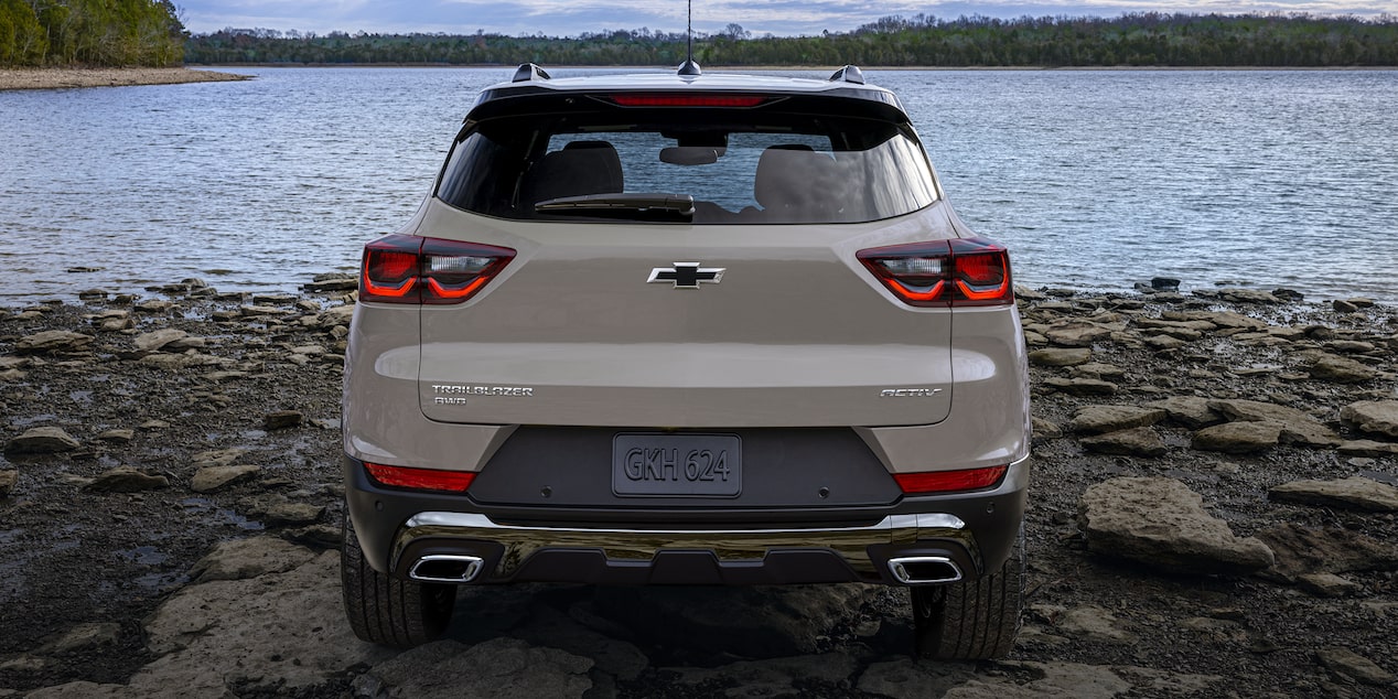 Vista trasera de Chevy Trailblazer 2026 estacionada, con un lago de fondo