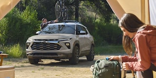 Chevy Trailblazer 2026 estacionada en un campamento, con una bicicleta acoplada a la parrilla portaequipajes en el techo