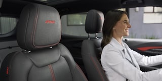 Una mujer sonriendo mientras conduce su Chevy Trailblazer 2026