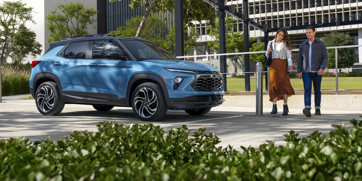 Una pareja caminando hacia su Chevy Trailblazer 2026 estacionada