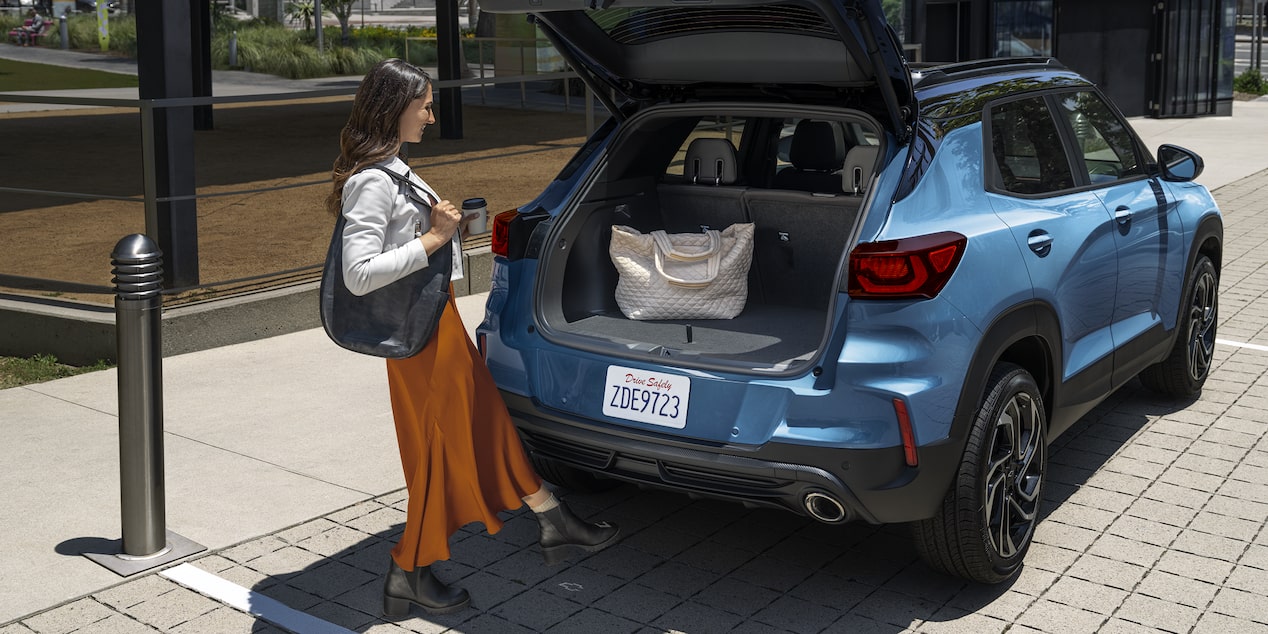 Una mujer coloca su bolso en la cajuela de la Chevy Trailblazer 2026