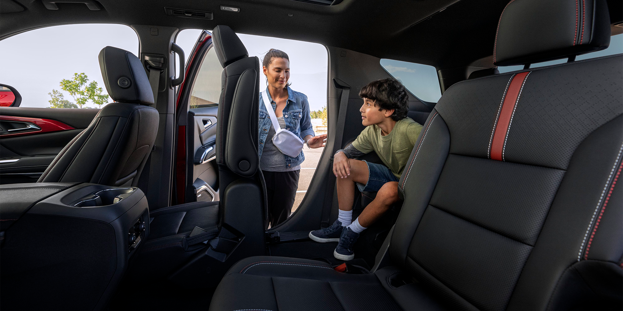 A Mother Folding Down the Second Row Seats For Her Child to Exit the Third Row in the 2026 Chevy Traverse