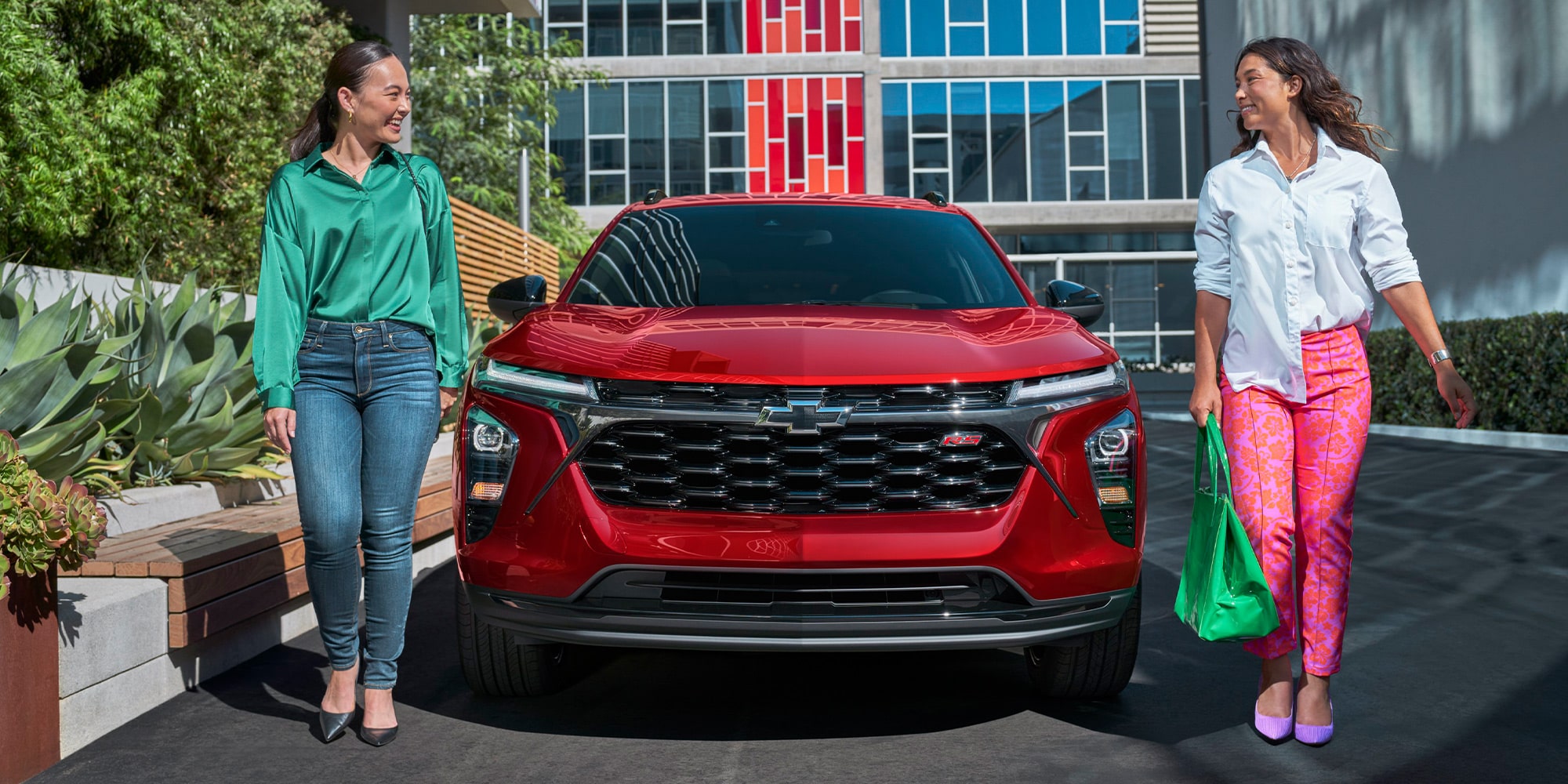 Two Women Walking Away from Their Parked 2026 Chevy Trax at a Mall