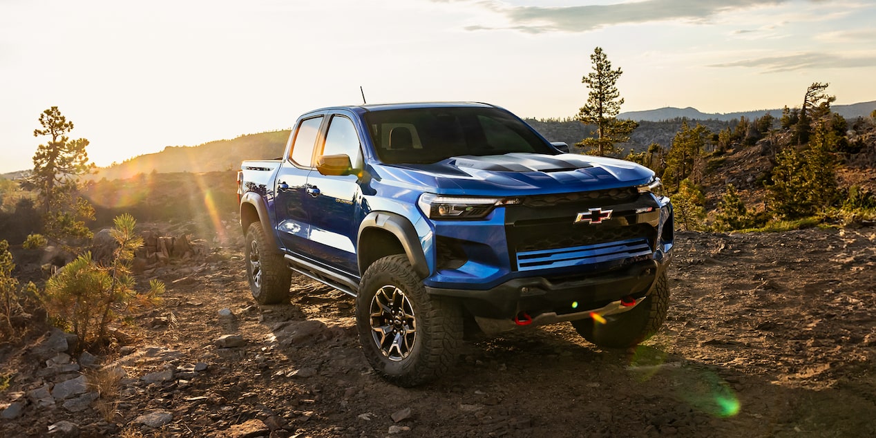 Three Quarters View of a Black Chevy Colorado Pickup Truck Going Down a Rocky Road