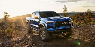 Three Quarters View of a Black Chevy Colorado Pickup Truck Going Down a Rocky Road