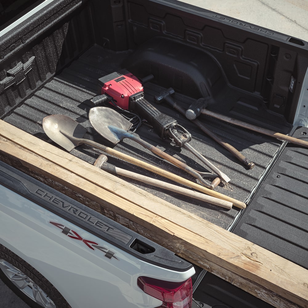 Construction equipment stowed on the Durabed of the 2026 Chevrolet Silverado LD.