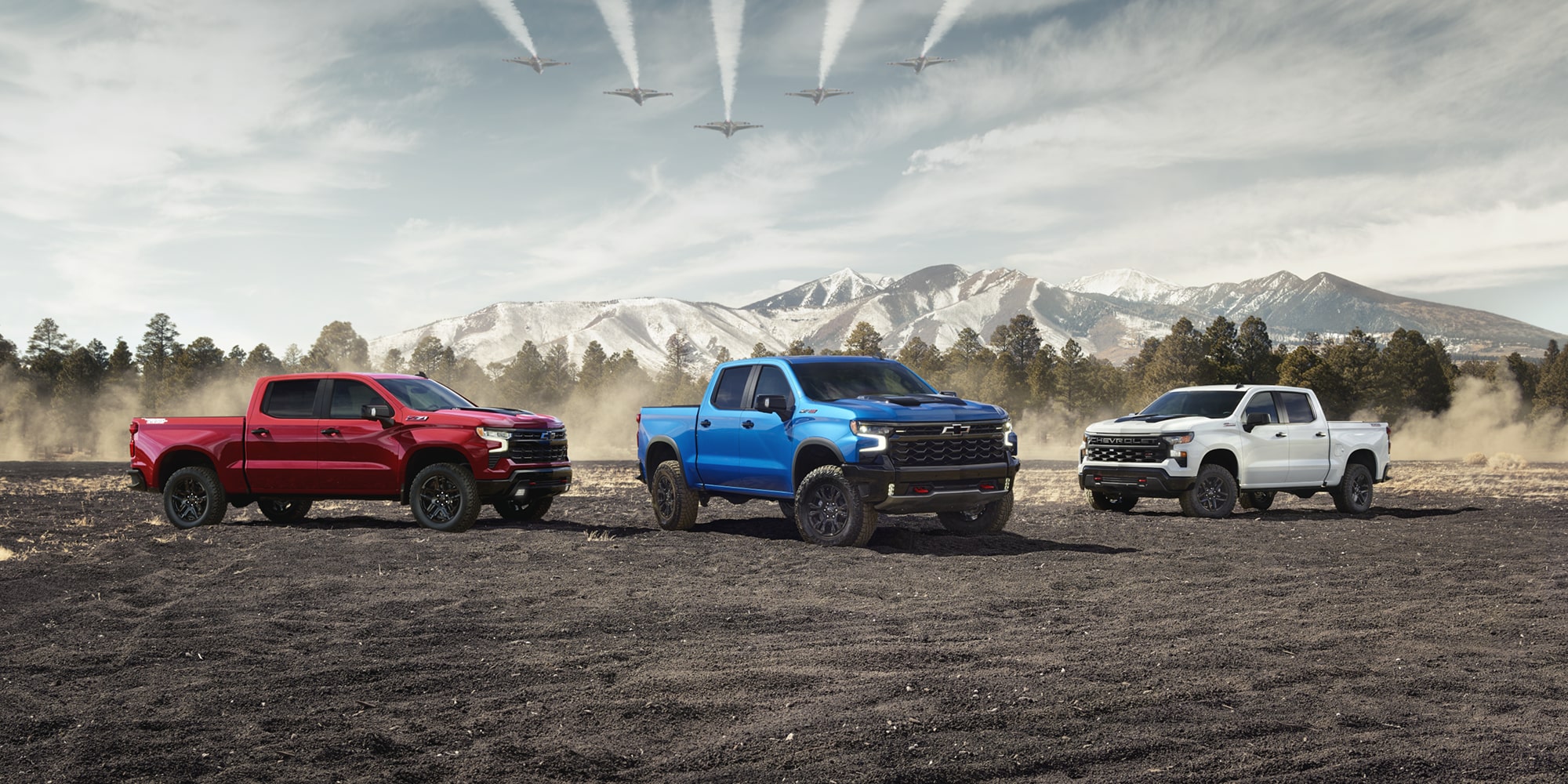 Three Chevrolet Silverado trucks parked near each other outdoors.