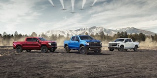 Three Chevrolet Silverado trucks parked near each other outdoors.