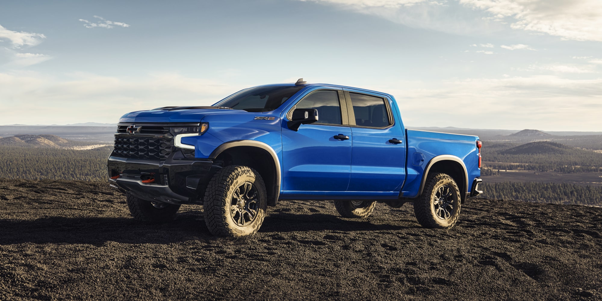 Side view of the 2026 Chevrolet Silverado LD Crew Cab ZR2 parked alone on a dirt terrain.