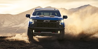 Front view of the 2026 Chevrolet Silverado LD Crew Cab ZR2 driving on a dusty terrain.