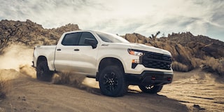 2026 Chevrolet Silverado LD Trail Boss driving on a sandy terrain.