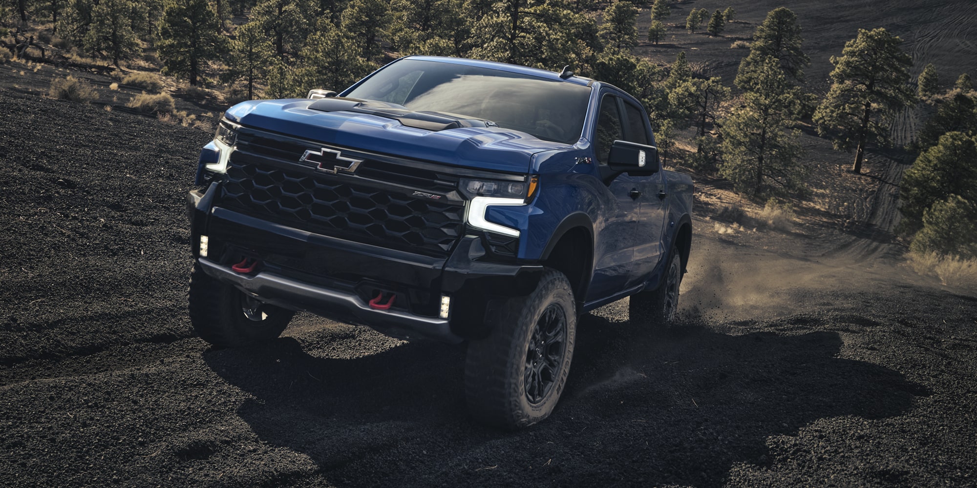 2026 Chevrolet Silverado LD Crew Cab ZR2 driving on a dirt terrain.