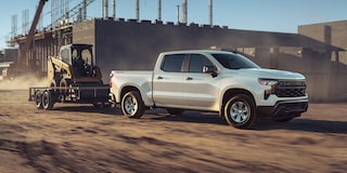 2026 Chevrolet Silverado LD Crew Cab WT towing a trailer on a construction site.
