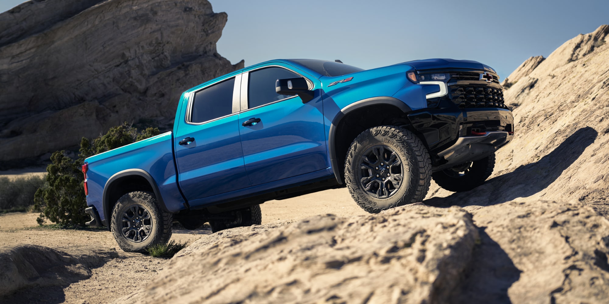 2026 Chevrolet Silverado LD parked by a rocky terrain.