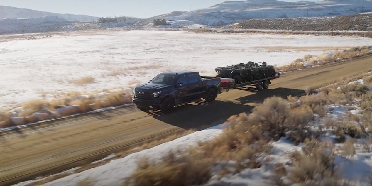 2026 Chevrolet Silverado LD towing a trailer on the road.