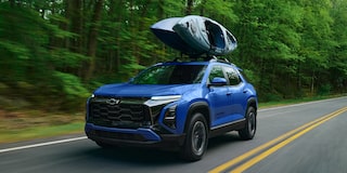 Low Angle Front View of a 2026 Blue Chevy Colorado Going Down a Rocky Road in a Forest