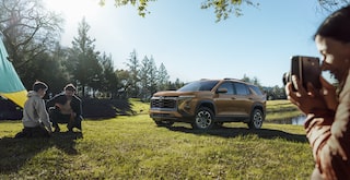2026 Chevrolet Colorado Trail Boss Midnight Edition shown in black, featured in a rural setting in a 3/4 front passenger-side view while off-roading.