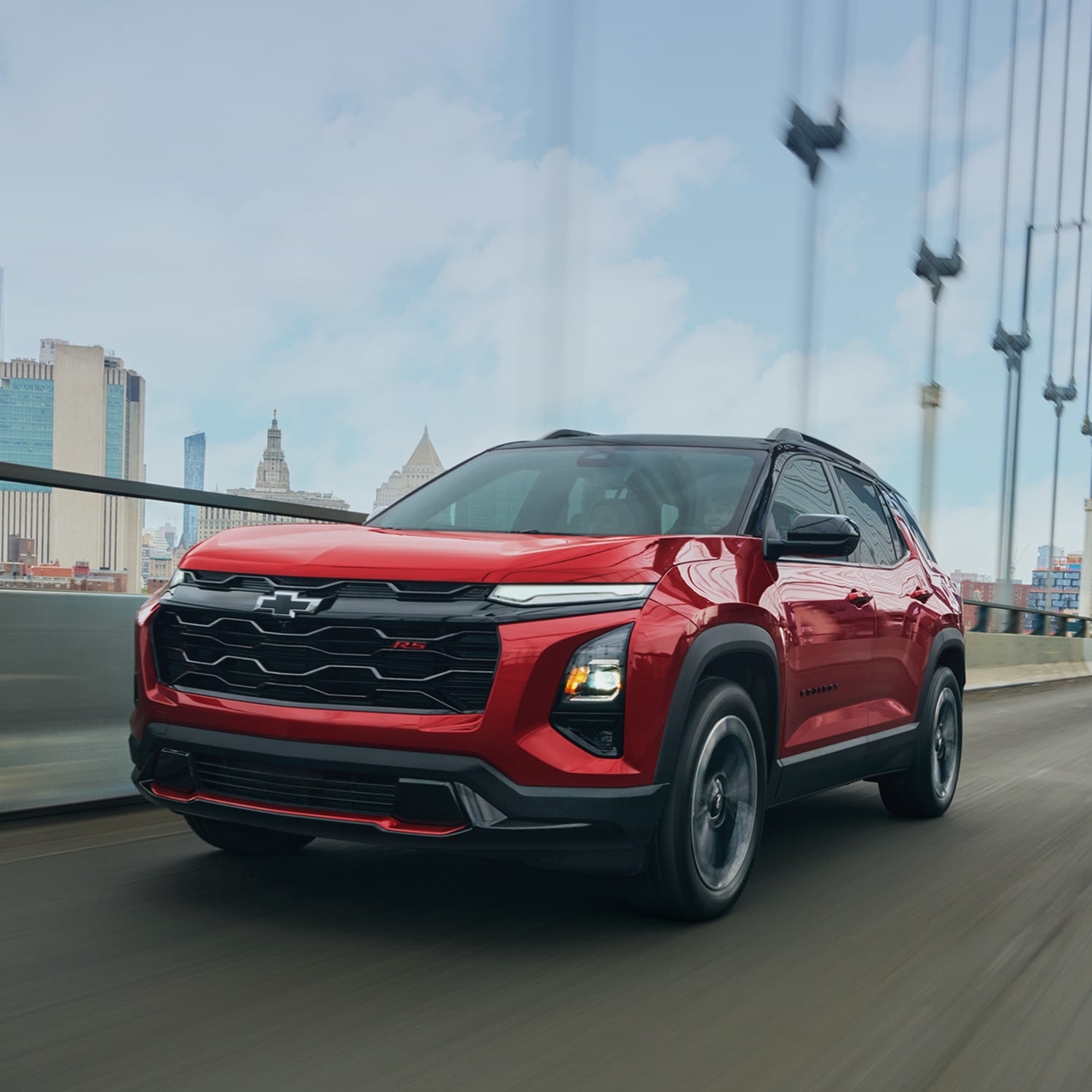 A Red 2027 Chevy Equinox Driving Through a Bridge Outlooking the City