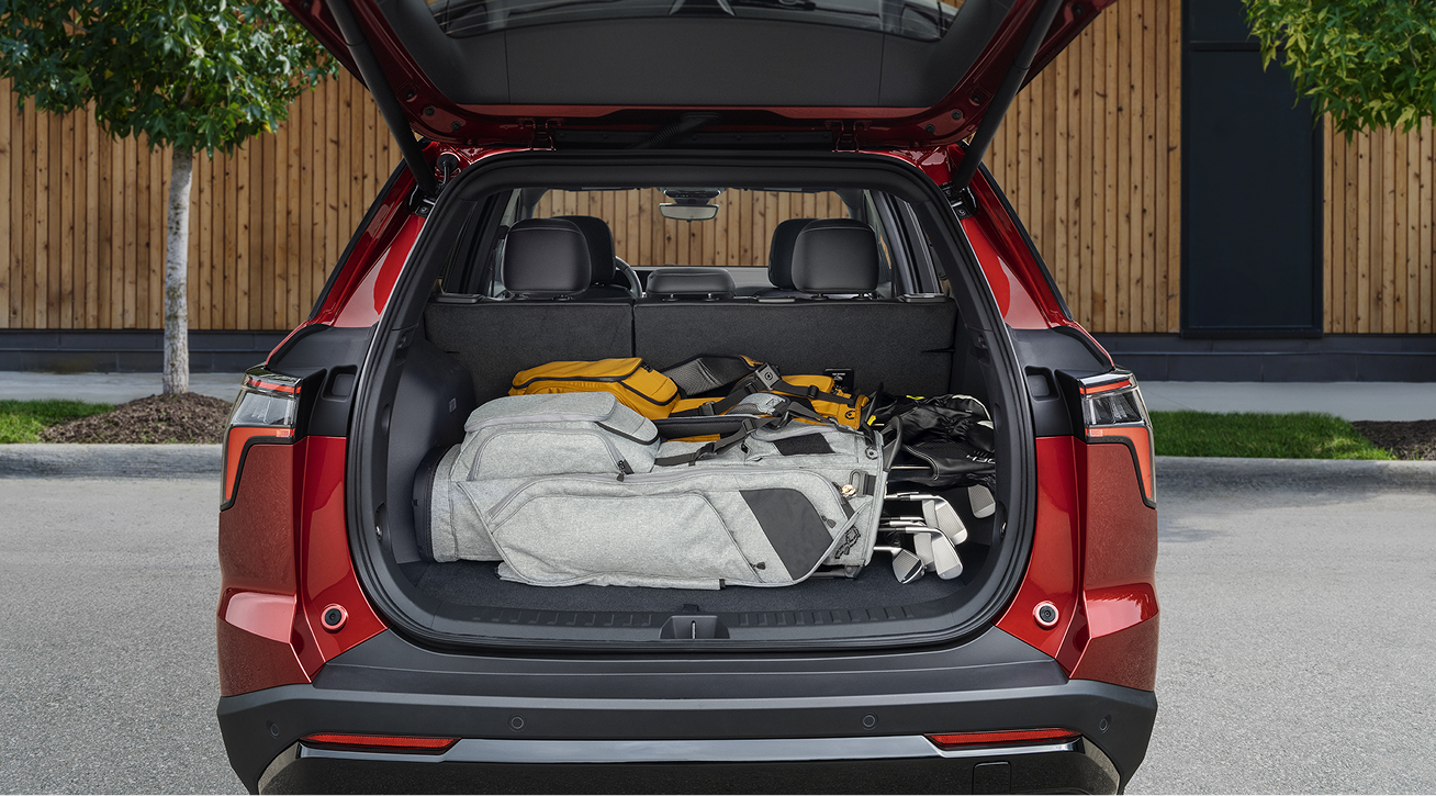 A Person with Helmet Is Checking the Cargo of a Red 2026 Chevy Colorado Pickup Truck