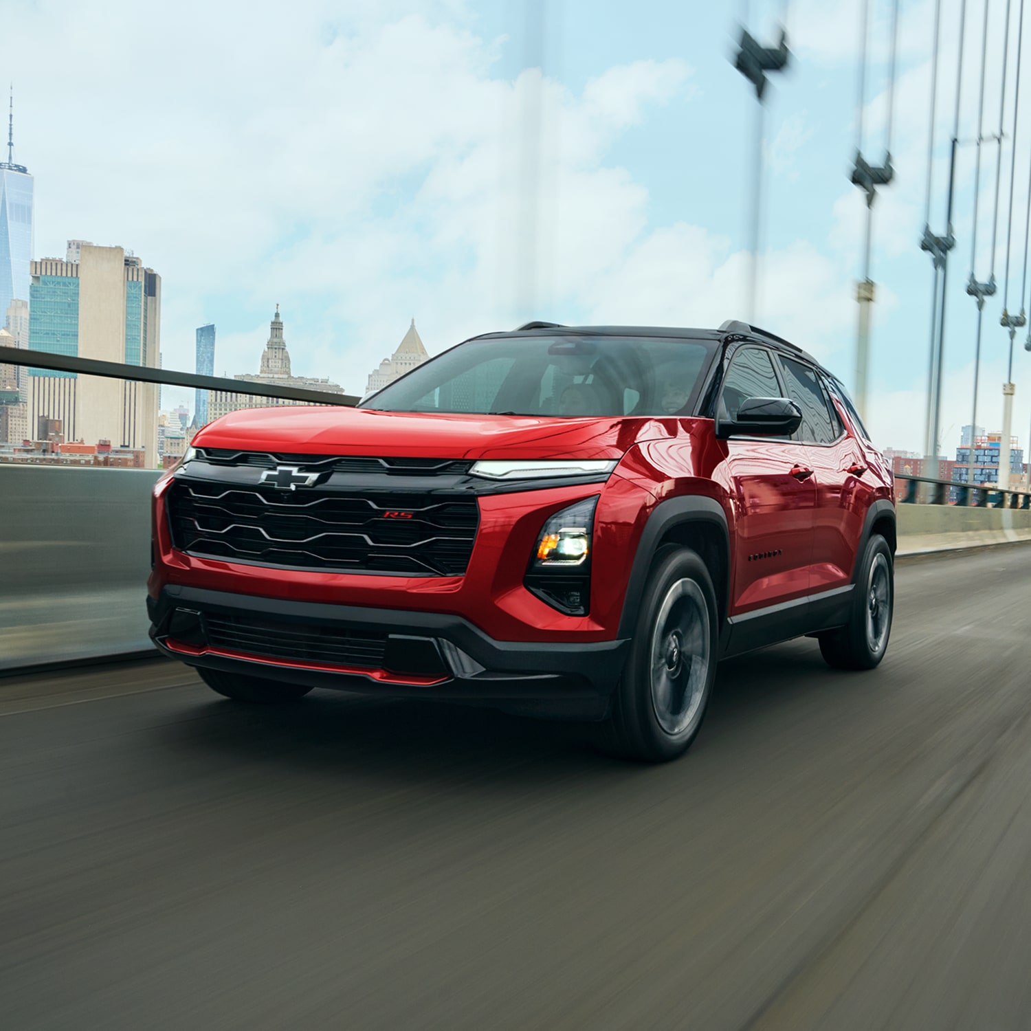 A Red 2027 Chevy Equinox Driving Through a Bridge Outlooking the City