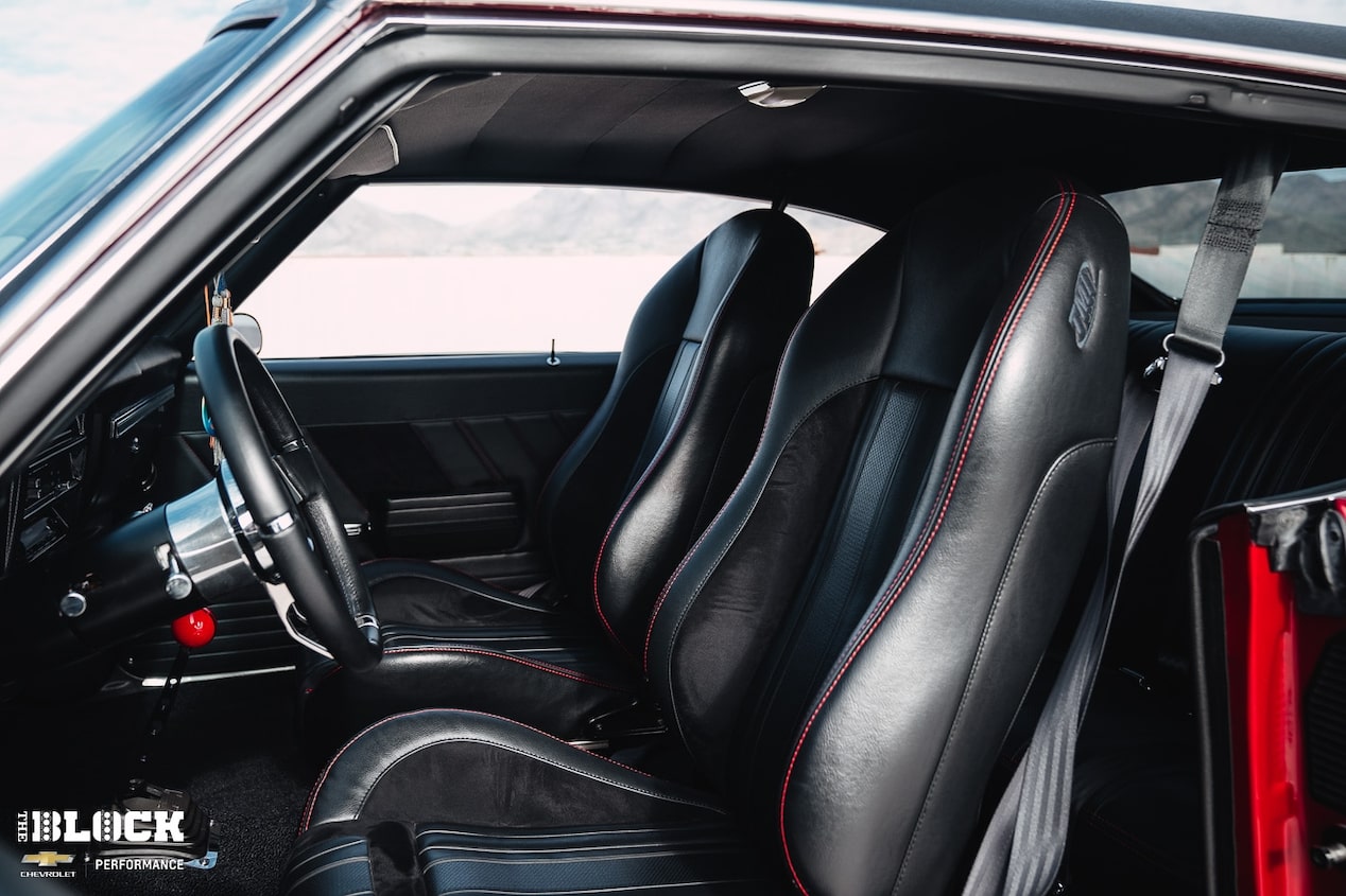 The interior includes many subtle details, including red accent stitching in the bucket seats.