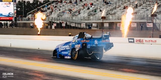 Vista amplia de tres cuartos de la parte trasera de un Funny Car Chevrolet despegando desde la línea de largada