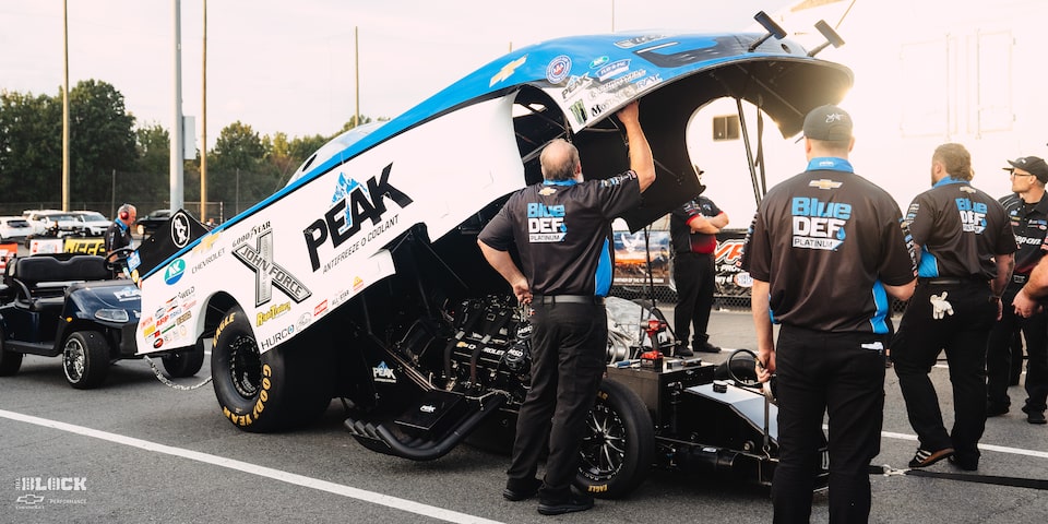 Un equipo de boxes inspecciona un Funny Car de Chevrolet