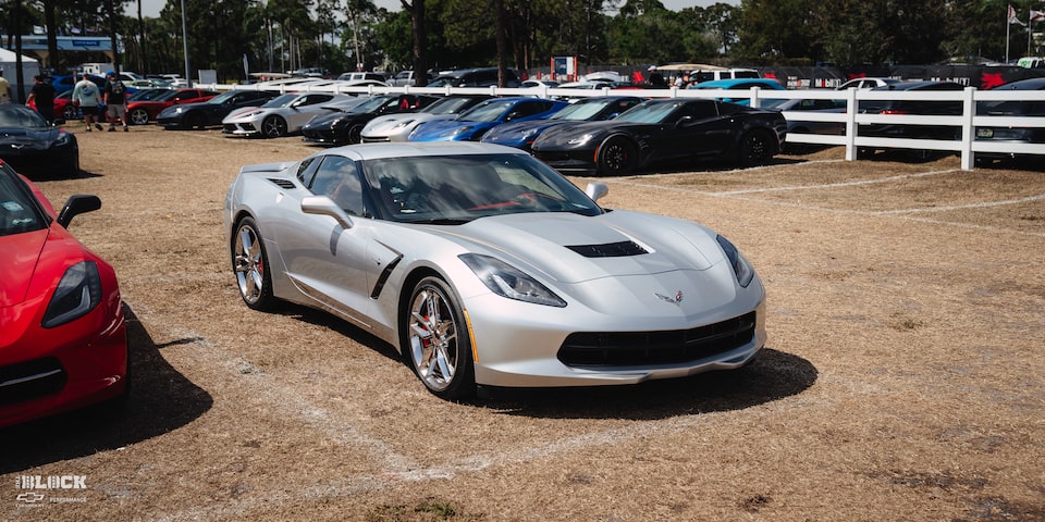Vista frontal de medio perfil de un Chevy Corvette Stingray 2014 estacionado sobre el césped