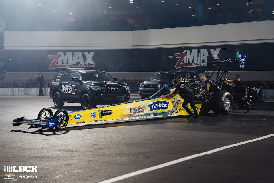 Force's team pushes her 11,000-horsepower Top Fuel dragster to the starting line. 