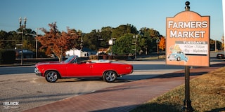 Wide Side View of a 1966 Chevrolet Chevelle SS Convertible Parked in an Empty Parking Lot Next to a Farmers Market Sign