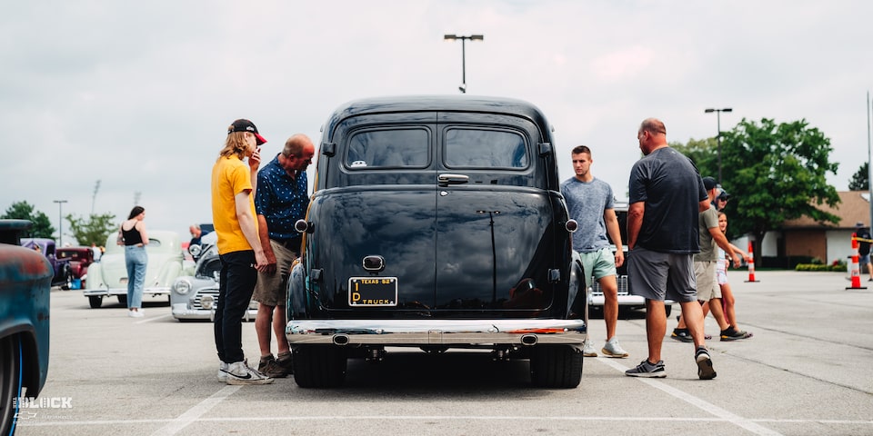 Rear View of David Pilgrim's 1952 Chevrolet Suburban in a Parking Lot With People Standing Around