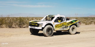 Front Side View of an Off-Road Chevy Truck Driving Through the Desert